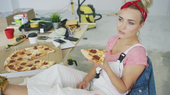 Female Carpenter Eating Pizza at Workplace