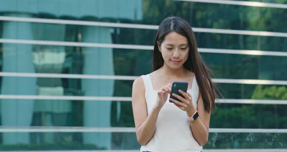 Woman use of smart phone with the office building background