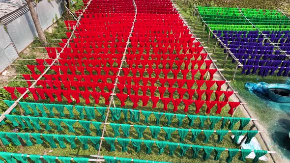 Aerial view of a person hanging to dry red cloths in Dhaka, Bangladesh.