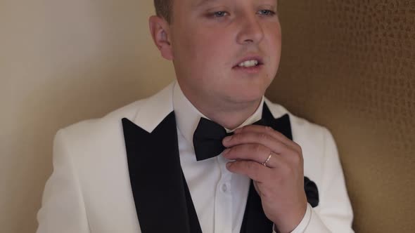 Groom Man Adjusts Bow Tie Preparing to Go to the Bride Businessman in White Shirt Wedding Day