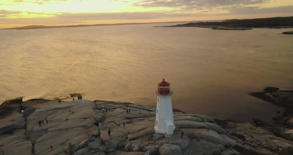 Stony seashore with lighthouse during sunset