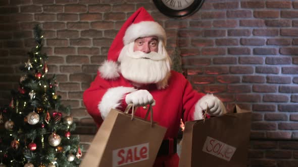 Christmas Gift Sales. Santa Is Holding Shopping Bags and Dancing Happy