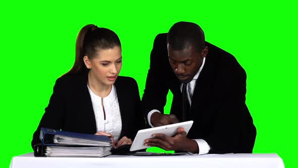 Two Businessman Discussing Documents on Laptop. Green Screen