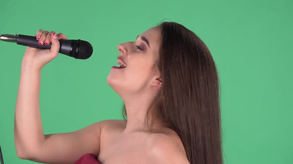 Portrait of Beautiful Young Woman Sings Song Into Microphone