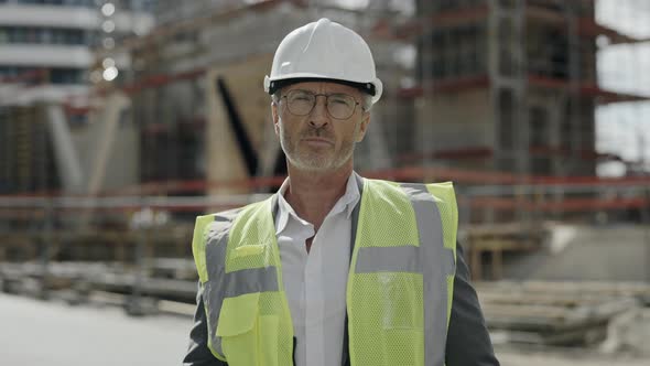 Mature Architect in Helmet Standing on Construction Site