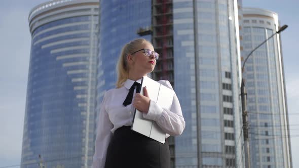 business woman with a laptop on the background of skyscrapers