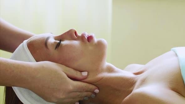 Young Woman Enjoys Facial Massage in Beauty Spa Salon on Wellness Treatment