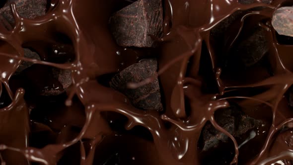 Super Slow Motion Shot of Raw Chocolate Chunks Falling Into Melted Chocolate at 1000 Fps