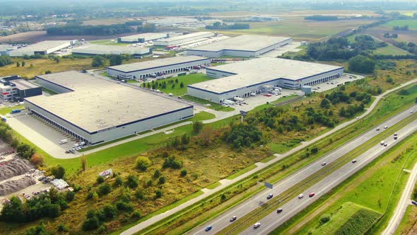 Big logistics terminal in countryside near highway, Delivery center traffic on the highway aerial sh