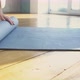 Lady Yoga Trainer Unrolls Grey Rubber Mat on Wooden Parquet - VideoHive Item for Sale