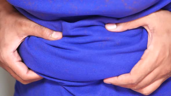 Man's Hand Holding Excessive Belly Fat, Overweight Concept