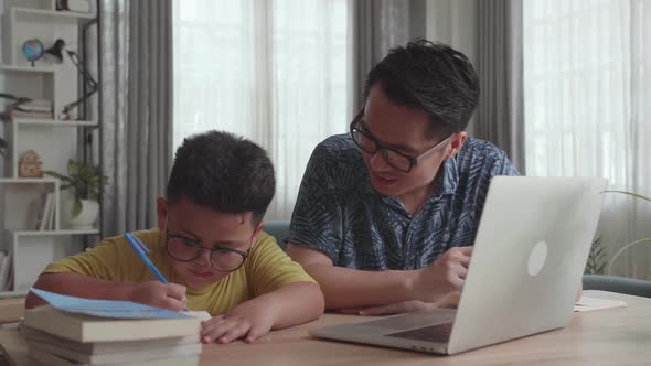 Caring Father Help Son Learn Online From Home. Boy Use Laptop Makes Notes