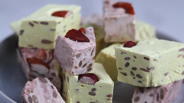 Pieces of halva on gray plate, revolves.