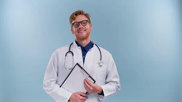 Happy Doctor Man Smiling Looking Aside Posing With Stethoscope Near Copy Space Standing In Studio