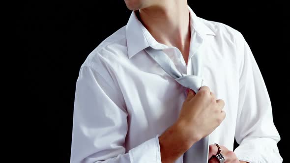 Androgynous man adjusting his tie