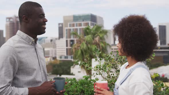 African man and mixed race woman discussing on rooftop