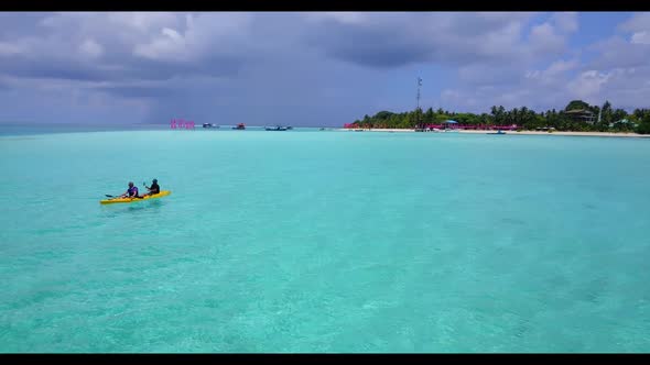 Man and woman tanning on perfect sea view beach wildlife by blue green sea with clean sand backgroun