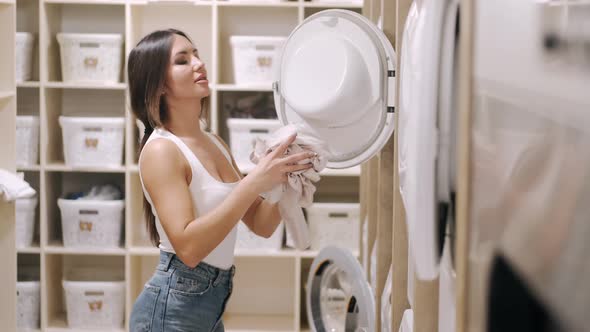 Younf Lady Checking Putting Clothes Into Wahing Machine
