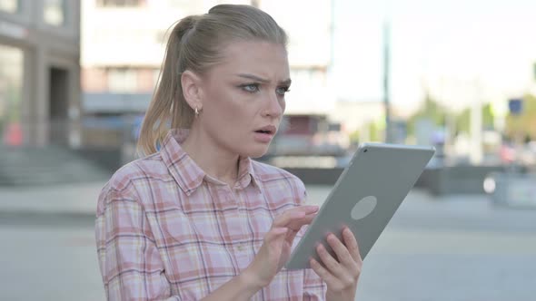 Upset Young Woman Reacting to Loss on Tablet Outdoor