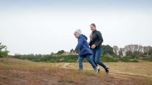 Video of Happy Smiling Young Mother with Little Son Climbing Up the Hill and Giving Five Each Other