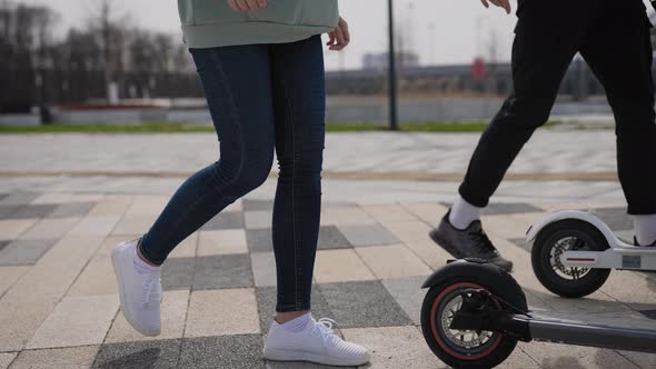 A Man and a Woman Ride Electric Scooters