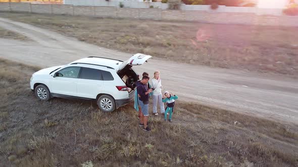 Departure of the Copter From the Car in the Setting Sun to the Height of a Bird's Flight