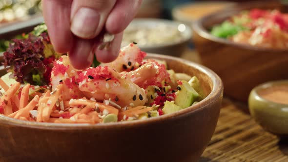 Sprinkling Sesame Seeds on Cooked Poke Bowl Closeup