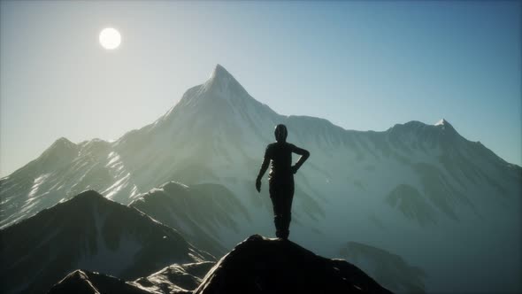 Woman Standing In Snow Wearing Warm Clothes In Mountains