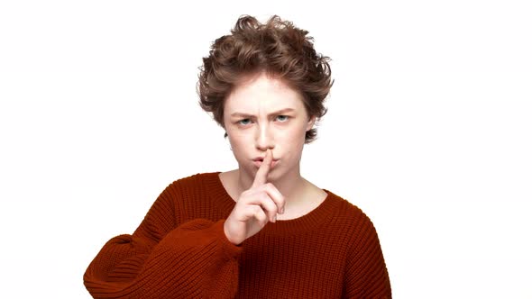 Portrait of Woman Looking on Camera with Strict Gaze Holding Index Finger on Lips and Asking to Keep