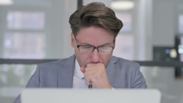 Close Up of Middle Aged Businessman with Laptop Coughing