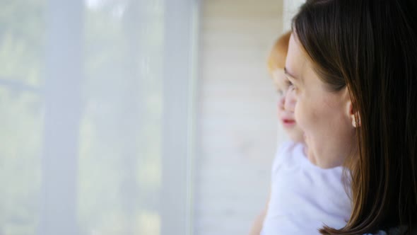 Close Up Video of Mother and Toddler Looking Through the Window