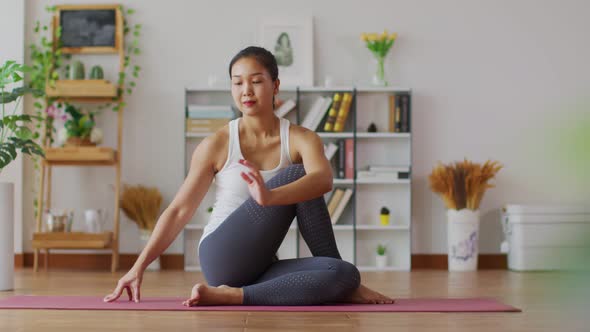 Asian woman practice yoga Seated Twist pose to meditation in bedroom