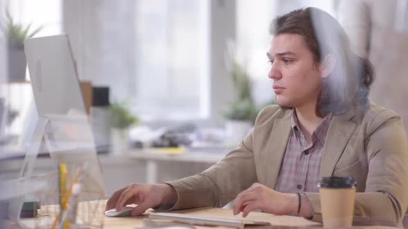 Man with Shoulder-Length Hair Working in Office