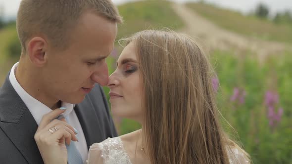 Groom with Bride Together on a Glade of Flowers. Wedding Couple. Happy Family