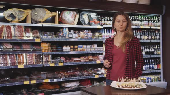 Mature Housewife Standing in Hypermarket and Tasting Fresh Snack