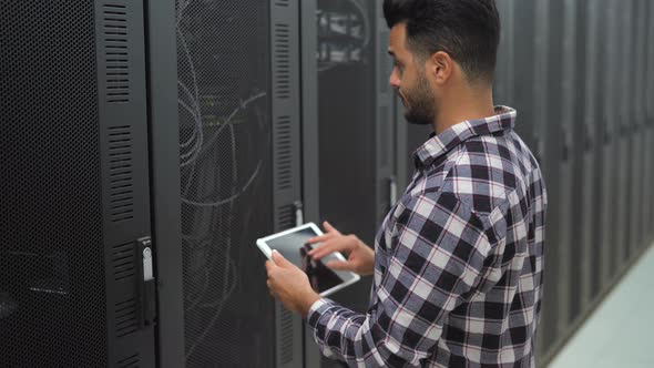 Male informatic engineer working inside server room database