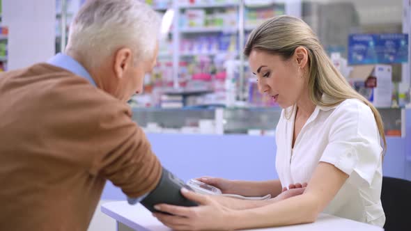 Portrait of Positive Woman Supporting Senior Man Talking Measuring Blood Pressure with