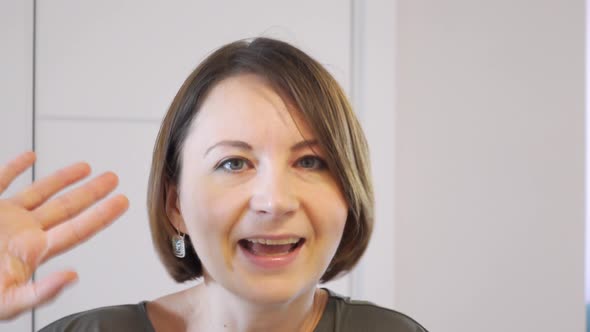 Portrait of Young Woman with Short Hair Who Dances Merrily Waves Her Hand in Greeting or Farewell