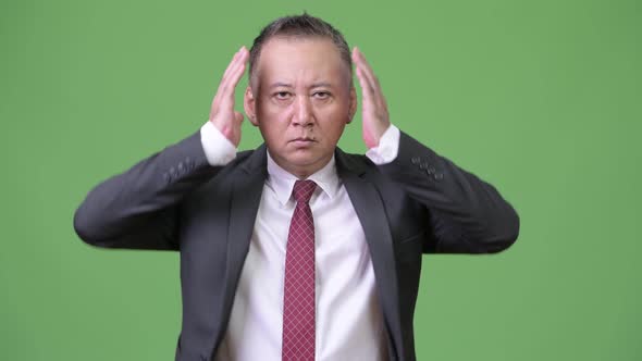 Mature Japanese Businessman Showing Three Wise Monkeys Concept