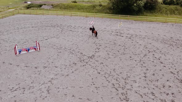 Woman Riding Horse Around Paddock