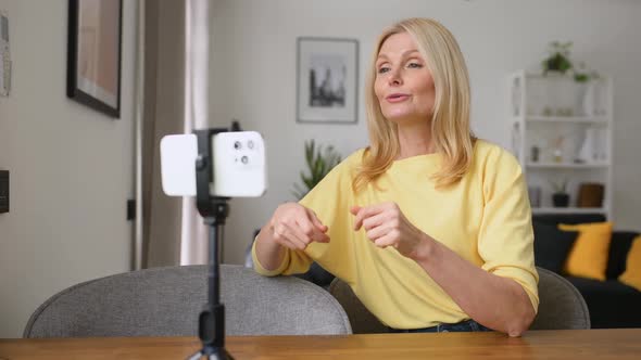 Senior Attractive Woman Speaking to the Camera on the Phone on a Tripod