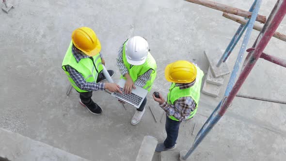 Engineers and construction contractors Holding a laptop to discuss building construction plans