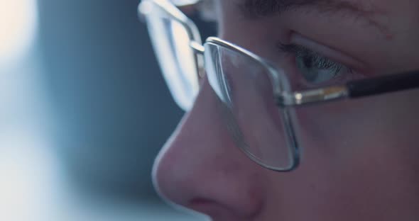 Eyes of a Teenager in Glasses Closeup  His Eyes Run Around the Computer Monitor