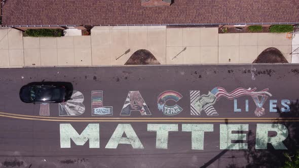 Black lives Matter street mural with cars driving over it