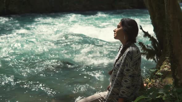 Smiling Girl Is Relaxing in Shadows of Trees in Woodland Area with View on River