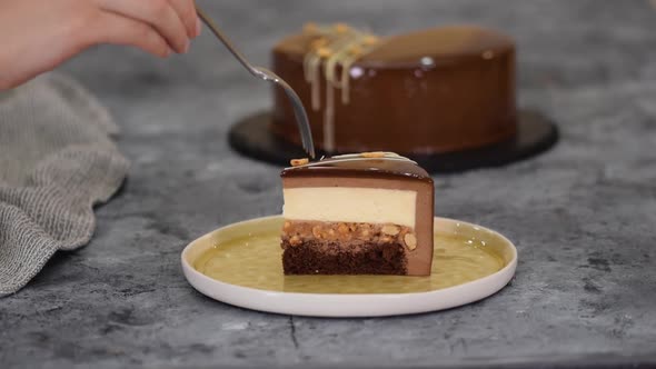 Piece of Chocolate Caramel Peanut Mousse Cake Snickers on a Plate