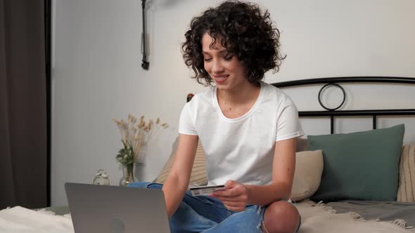 Smiling Woman Enters Credit Card Code to Pay Gifts Online Shopping Via Laptop