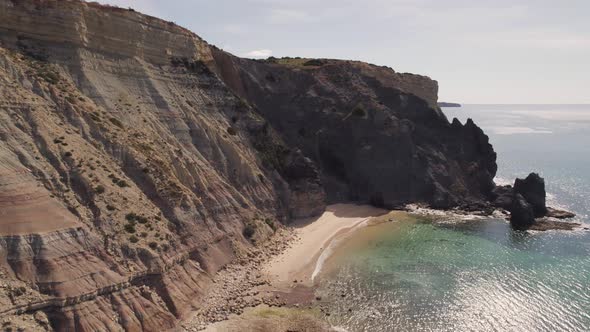 Empty beach along Algarve Atlantic coast, crystal clear sea water.  Orbiting shot