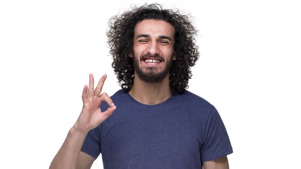 Portrait of Satisfied Guywith Dark Locks and Mustach Wearing Casual Clothing and Showing Ok or