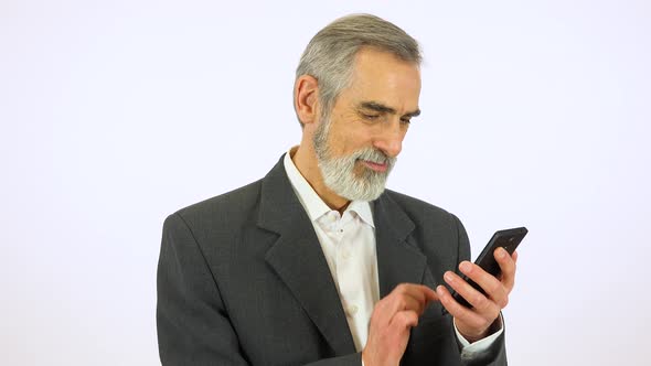 An Elderly Man Works on a Smartphone with a Smile - White Screen Studio